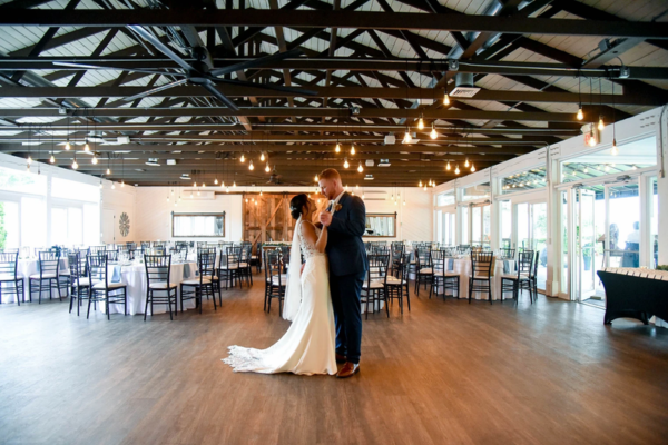couple dancing on the dance floor inside the reception room at the Farmhouse