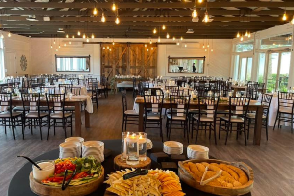 Food setup in The Farmhouse reception room, with bulb lights and wooden barn door