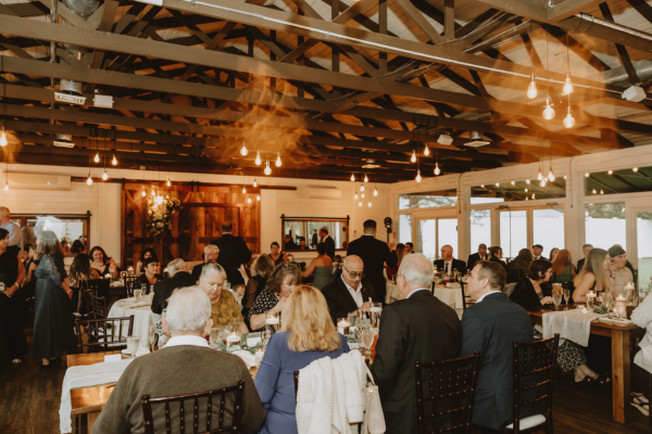 Guests gathered at tables in the reception room at The Farmhouse