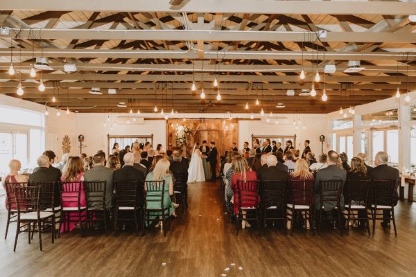 Wedding ceremony inside the handsomely rustic and charming Farmhouse venue.
